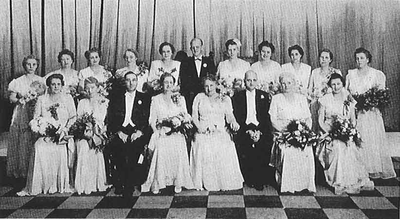 A black and white photo of a wedding party.