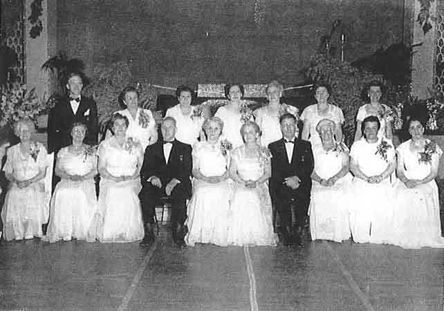 A group of people in formal attire posing for a photo.