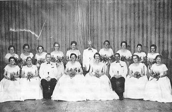 A group of people in white posing for a photo.