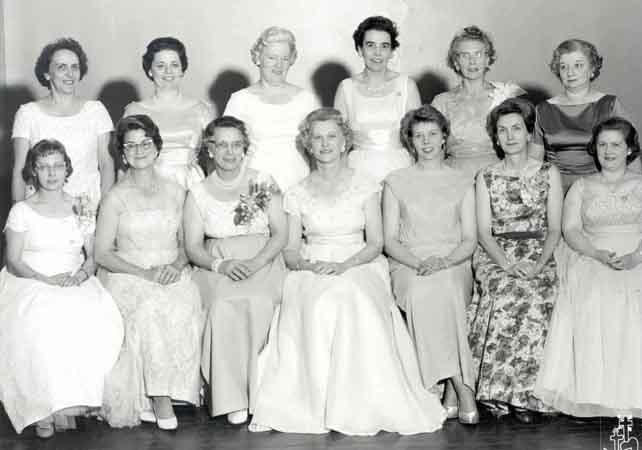 A group of women in formal dresses posing for a photo.