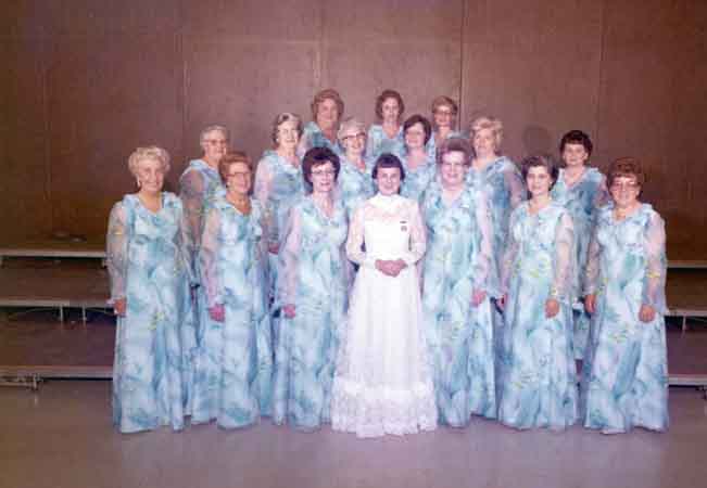 A group of women in blue and white dresses posing for a photo.