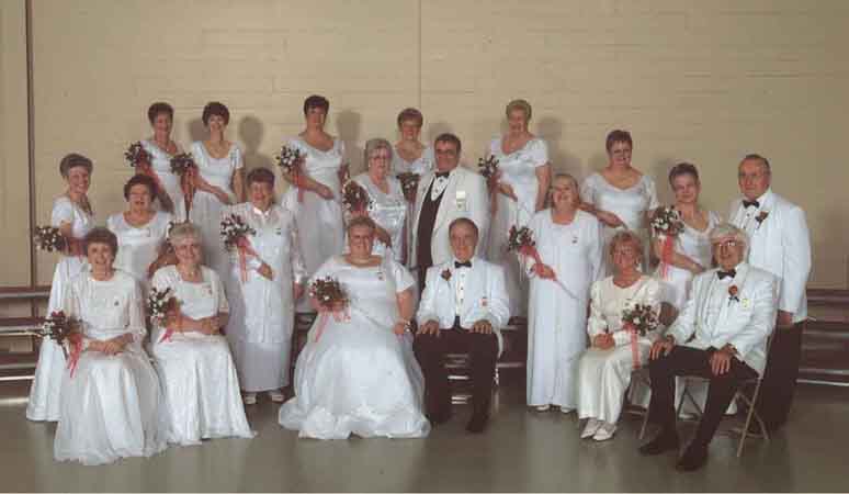 A group of people dressed in white posing for a picture.