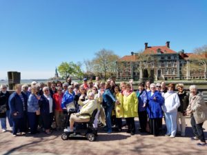 A group of women standing in front of a Ellis Island.