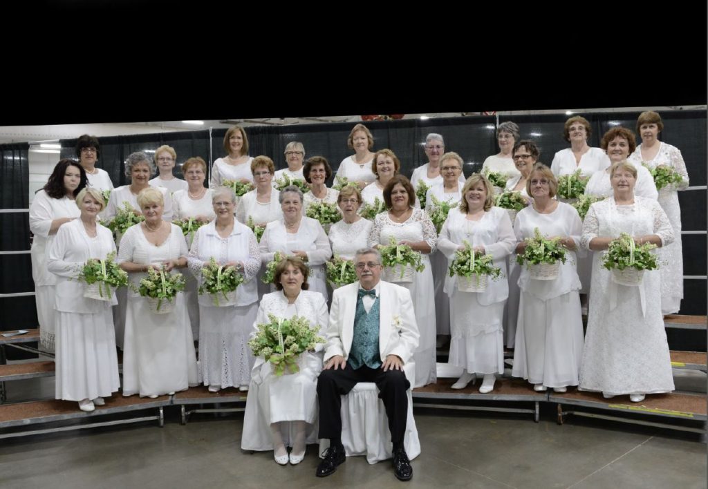 A group of people in white posing for a picture.