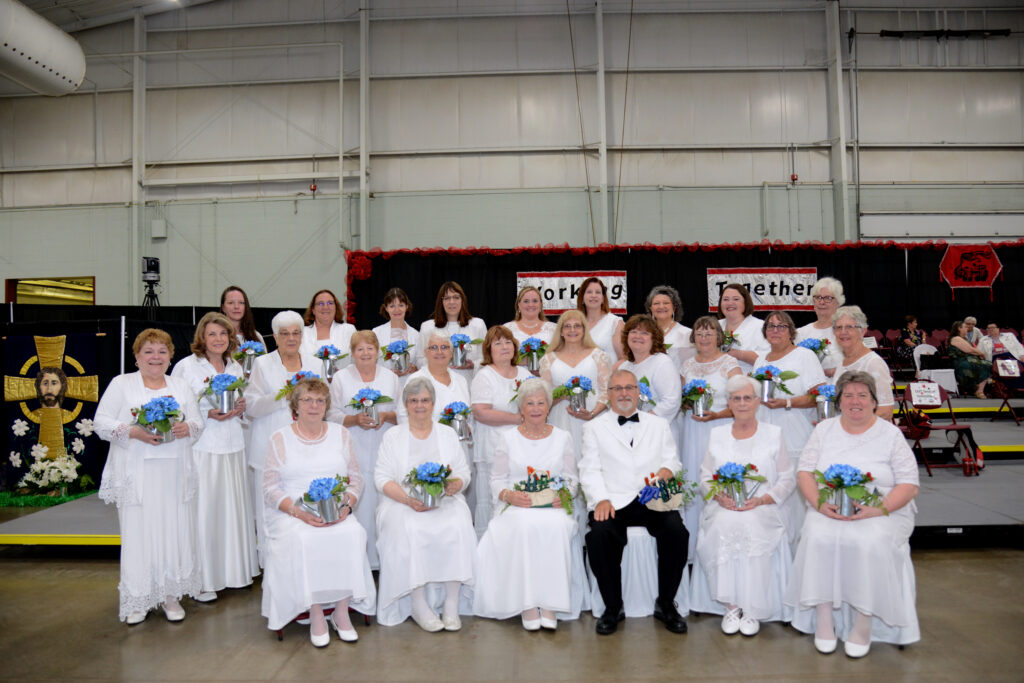 A group of people in white posing for a picture.